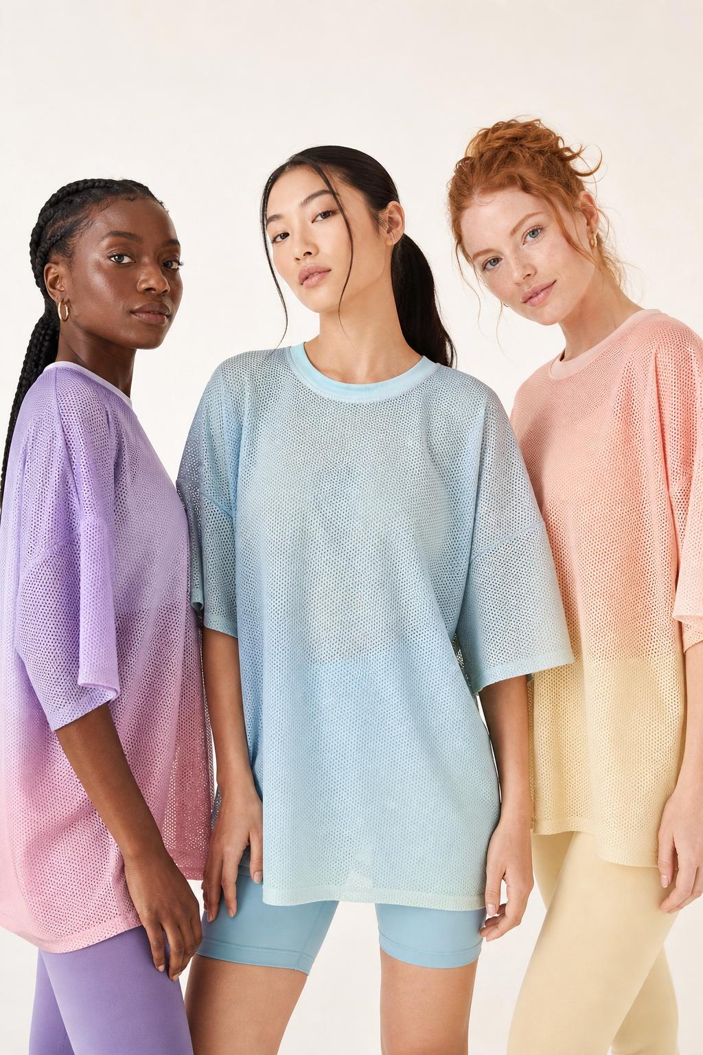 Three women wearing pastel mesh shirts and cream sweatpants